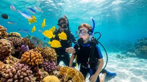 Baptême de plongée : prix, âge et déroulé Un enfant et son instructeur découvrant des poissons tropicaux lors d'un baptême de plongée dans un récif corallien.